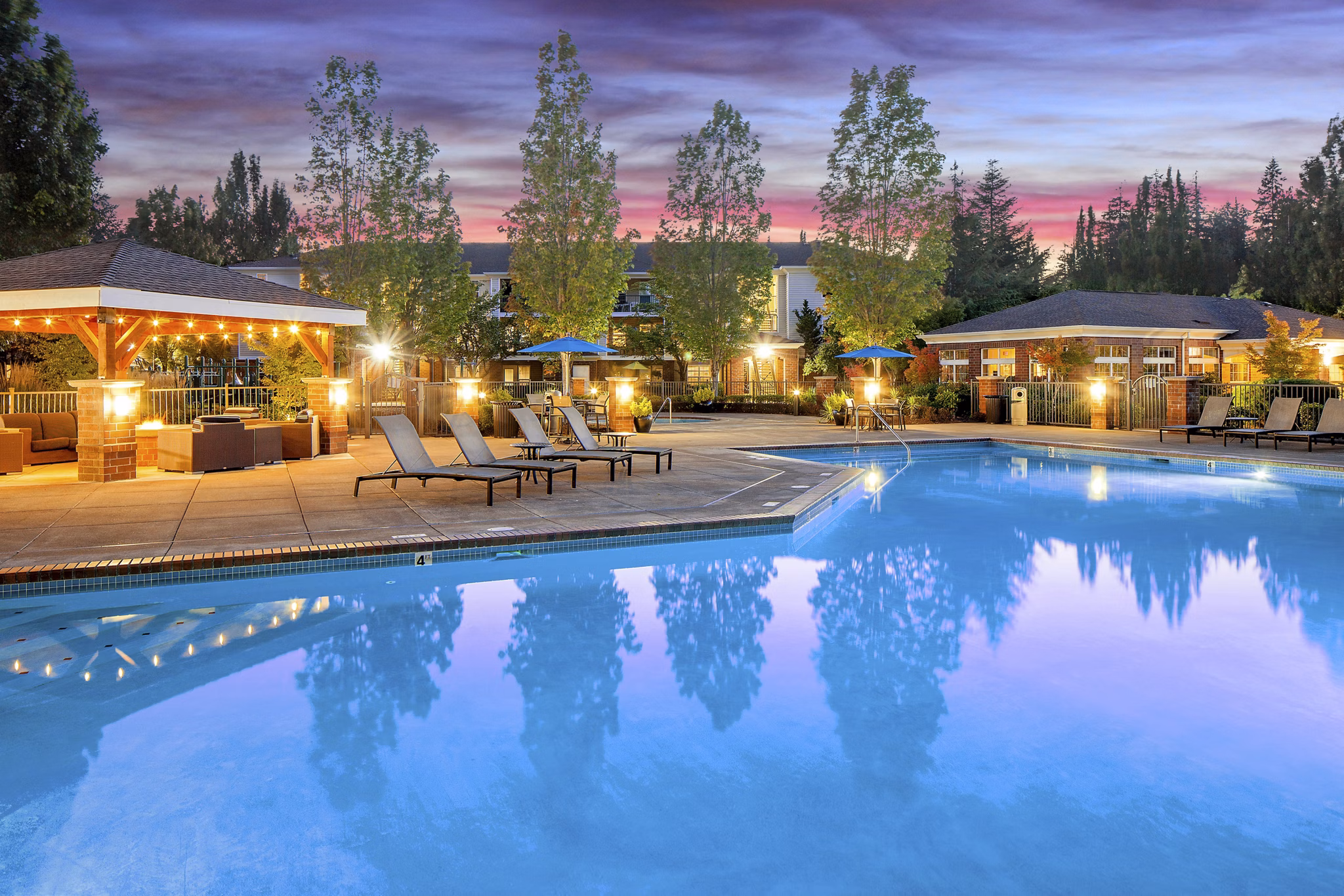 Outdoor pool with lounge chairs at Arya at Hedges Creek Apartments, luxury living in a serene setting