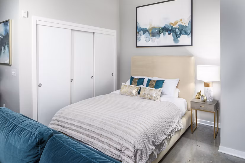 Cozy bedroom with modern decor and ample natural light at Park 19 Apartments, luxury living in a serene community