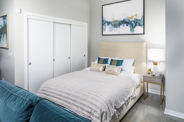 Cozy bedroom with modern decor and ample natural light at Park 19 Apartments, luxury living in a serene community
