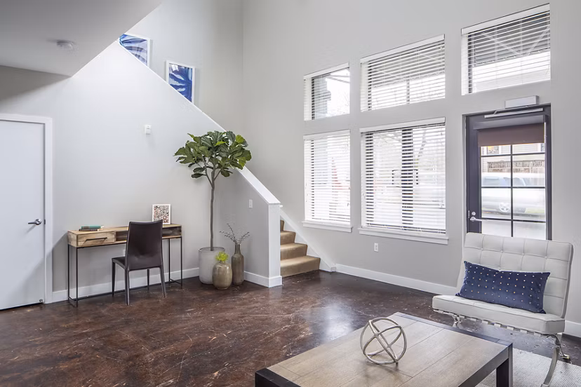 Living room with modern furnishings and large windows at Park 19 Apartments