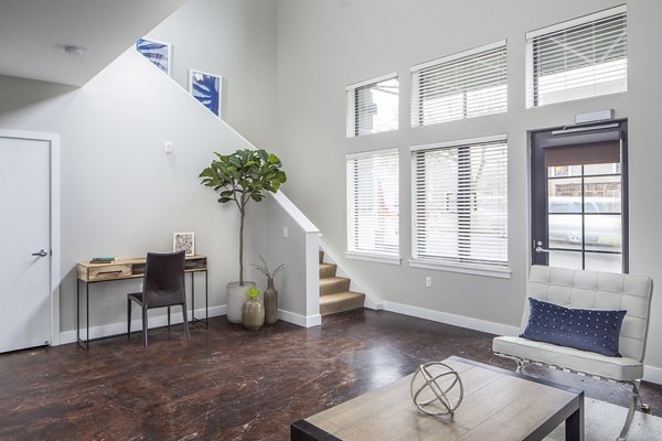 Living room with modern furnishings and large windows at Park 19 Apartments