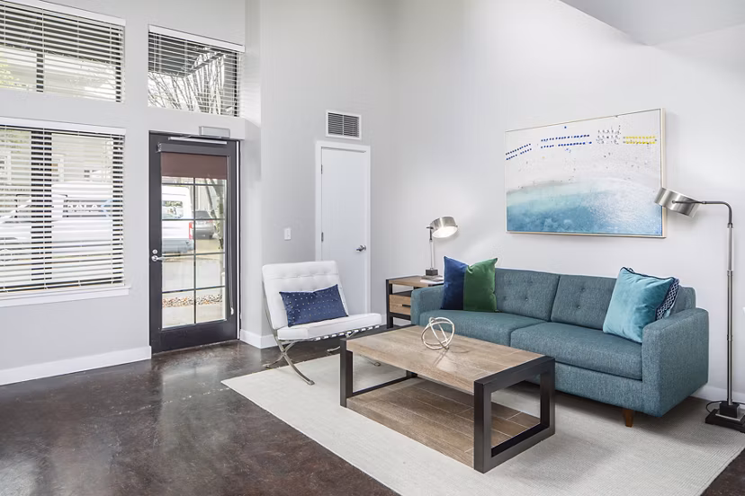 Living room with modern decor and large windows in Park 19 Apartments, offering luxury living in a serene environment