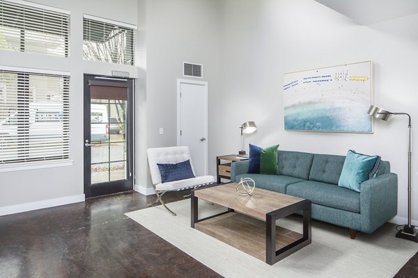 Living room with modern decor and large windows in Park 19 Apartments, offering luxury living in a serene environment
