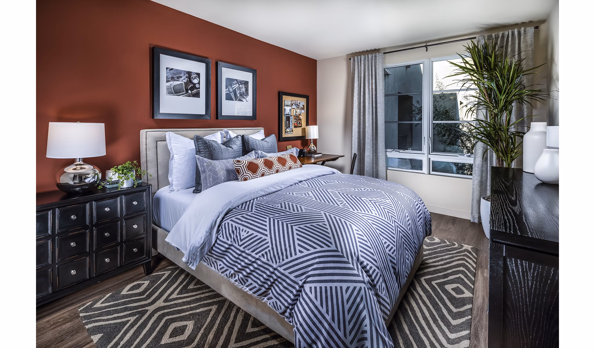 Trio Apartments: Cozy bedroom with modern furnishings and large windows in luxury setting