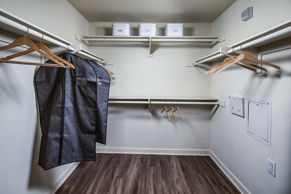 Cozy bedroom with modern decor at Trio Apartments featuring plush bedding and ample natural light