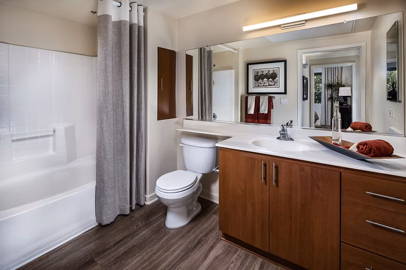 Modern bathroom featuring sleek fixtures and glass shower in Trio Apartments