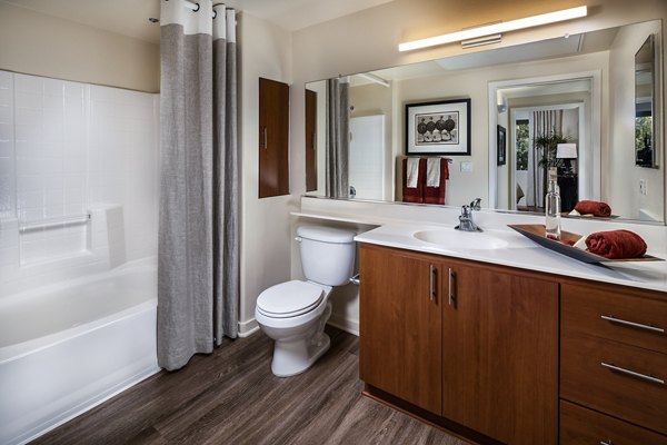 Modern bathroom featuring sleek fixtures and glass shower in Trio Apartments