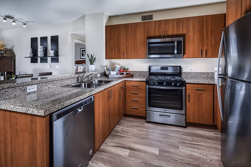 Modern kitchen with sleek countertops and stainless steel appliances in Trio Apartments