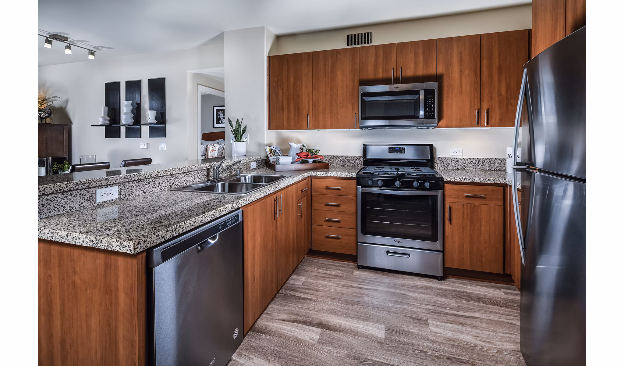 Modern kitchen with sleek countertops and stainless steel appliances in Trio Apartments
