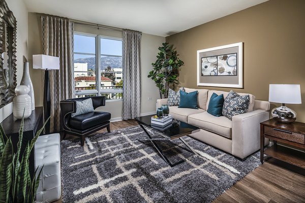 Cozy living room with modern furnishings and ample natural light at Trio Apartments