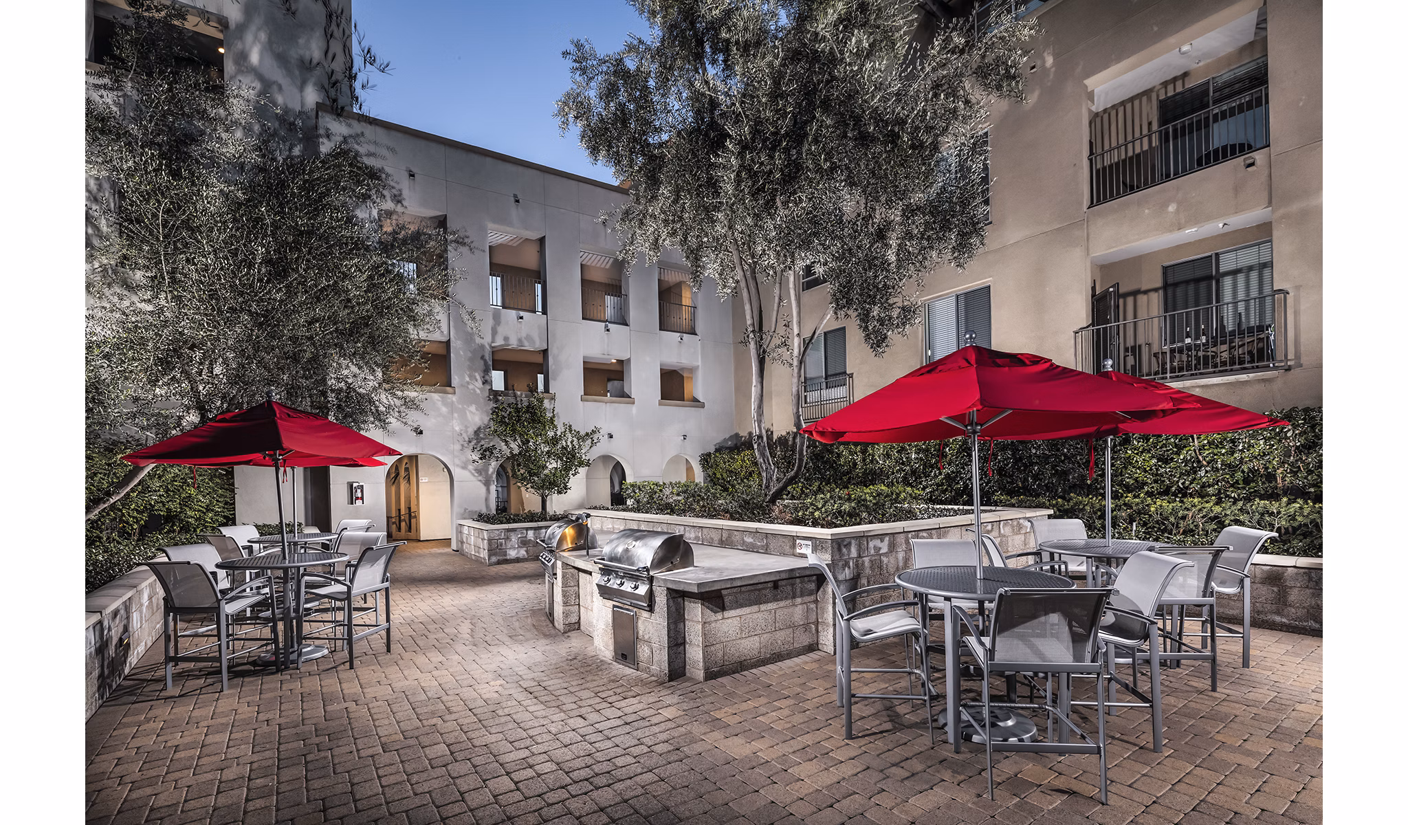 Spacious outdoor grill area with modern seating at Trio Apartments, perfect for community gatherings and barbecues