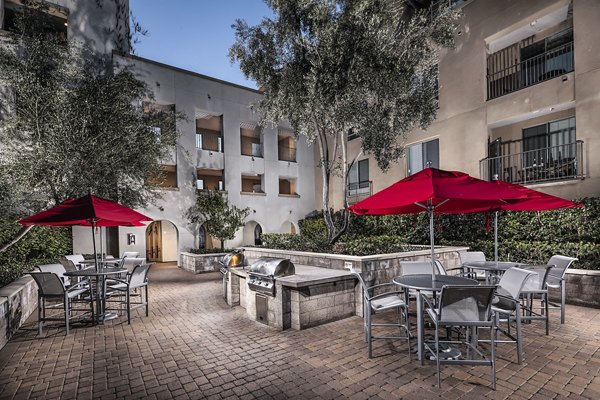 Spacious outdoor grill area with modern seating at Trio Apartments, perfect for community gatherings and barbecues