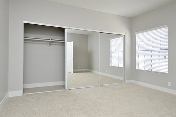Cozy bedroom featuring chic decor and ample lighting in Westcreek Apartments