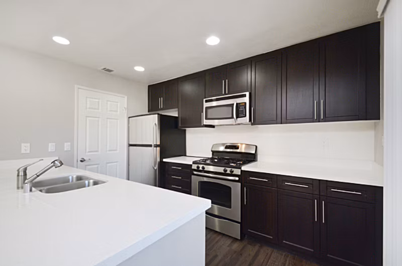 Modern kitchen with stainless steel appliances and granite countertops in Westcreek Apartments