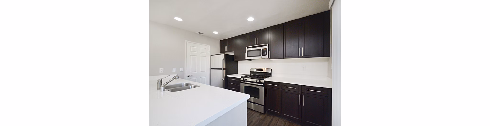 Modern kitchen with stainless steel appliances and granite countertops in Westcreek Apartments