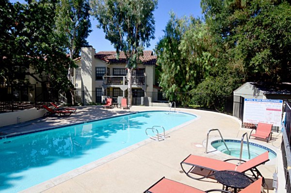 Refreshing outdoor pool at Westcreek Apartments offering lounge seating and scenic landscape Perfect for relaxing in a luxury apartment setting