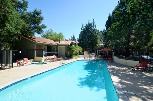 Resort-style pool surrounded by lush landscaping at Westcreek Apartments
