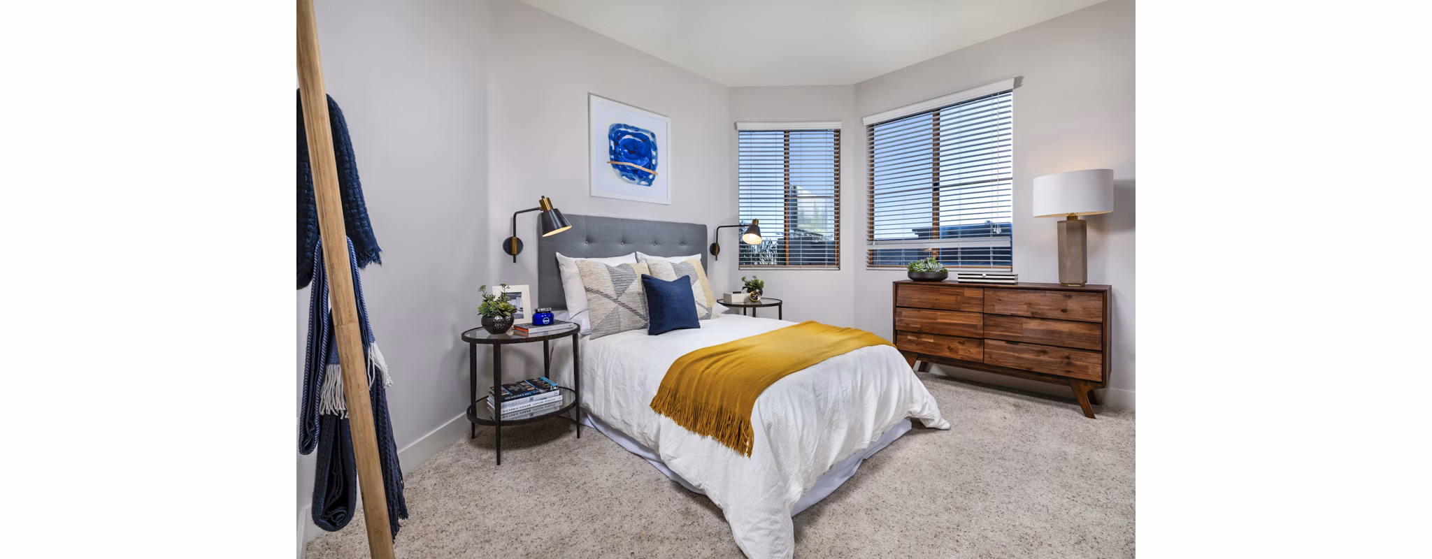 Elegant bedroom with modern decor at Legacy at Westwood Apartments, featuring luxurious bedding and ample natural light