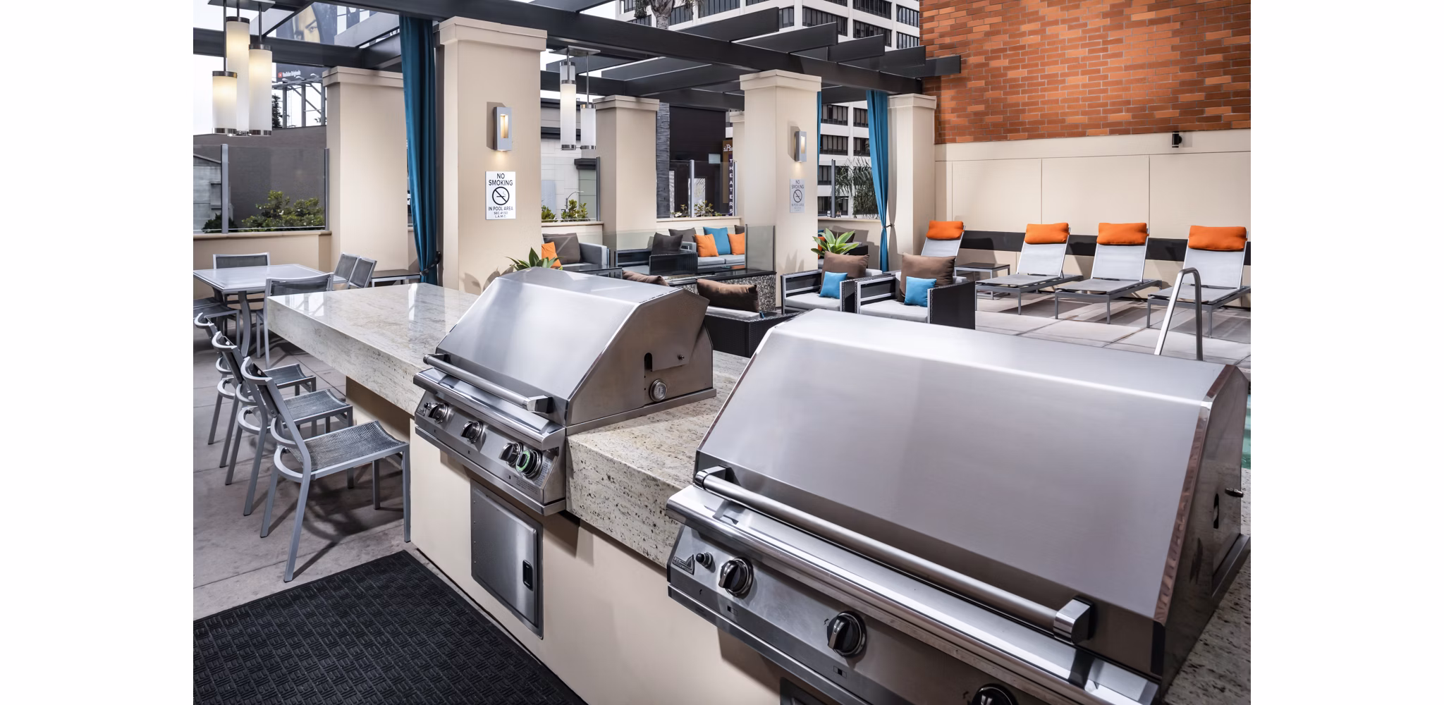 Outdoor grill area at Legacy at Westwood Apartments featuring modern stainless steel grills and seating for community gatherings