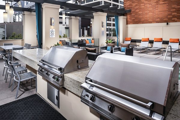 Outdoor grill area at Legacy at Westwood Apartments featuring modern stainless steel grills and seating for community gatherings
