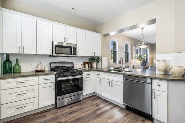 Modern kitchen with stainless steel appliances and granite countertops at Rolling Hills Gardens Apartments