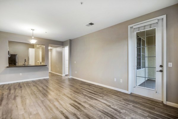 Bright living room with modern furnishings and large windows at Rolling Hills Gardens Apartments