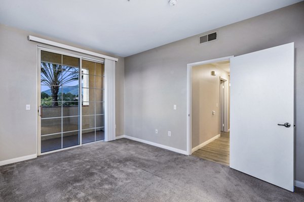 Spacious living room featuring modern decor and large windows at Rolling Hills Gardens Apartments, luxury living by Greystar
