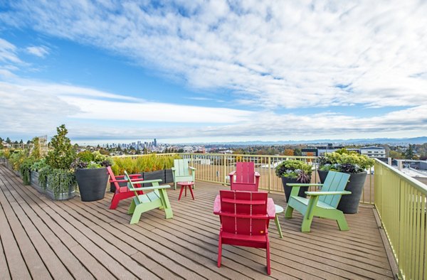 Patio with modern seating and lush greenery at Link Apartments, providing a serene outdoor space for relaxation and gatherings