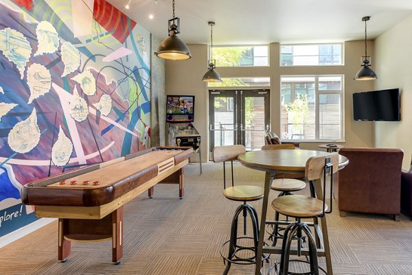 Clubhouse with modern furnishings and vibrant artwork at Mural Apartments, offering a luxurious space for social gatherings and relaxation