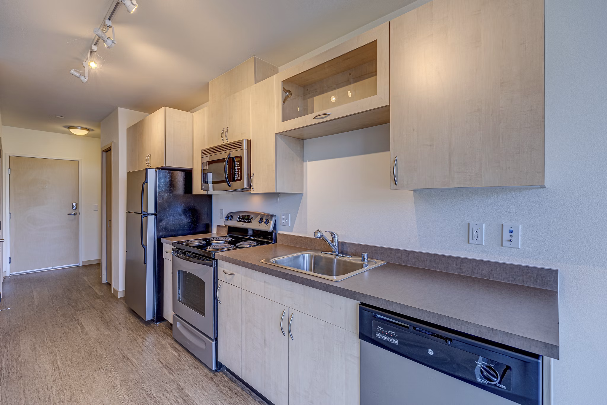 Modern kitchen with sleek appliances and island seating at Prescott Apartments