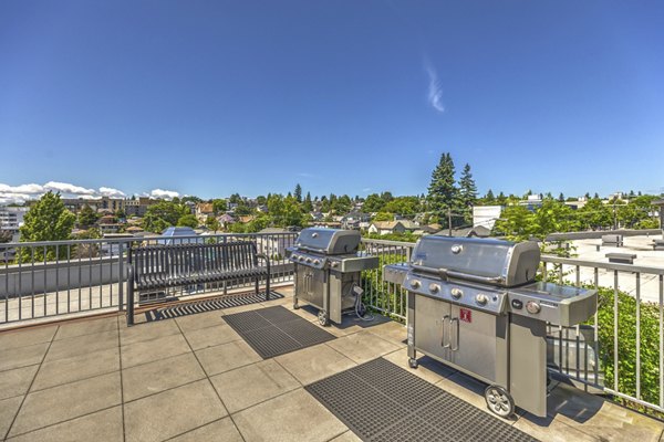 BBQ grill area with seating and landscaped surroundings at Prescott Apartments, ideal for outdoor entertaining and gatherings