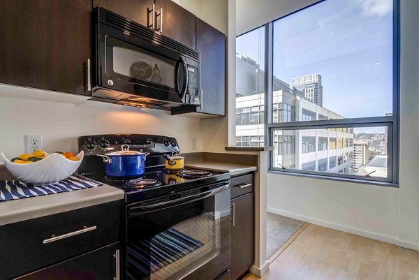 Modern kitchen with stainless steel appliances and granite countertops at Aspira Apartments