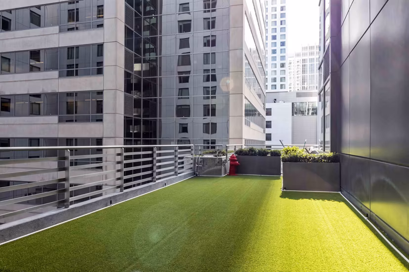 Dog-friendly fenced park at Aspira Apartments with agility structures and seating areas