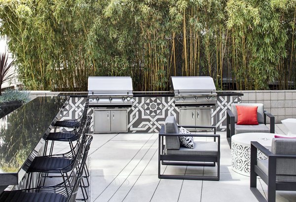 Grill area with modern seating and barbecue facilities at Tenth&G Apartments