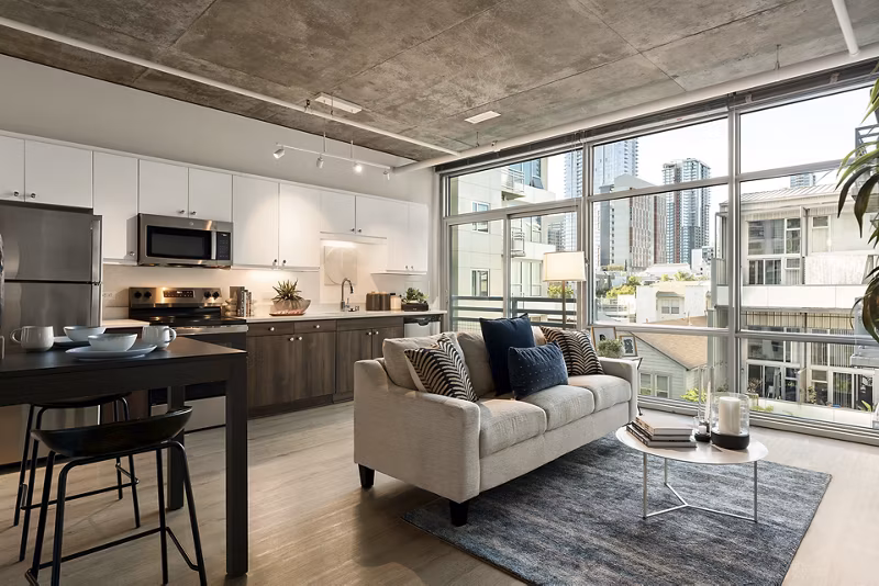 Bright living room with modern decor and large windows at Tenth&G Apartments