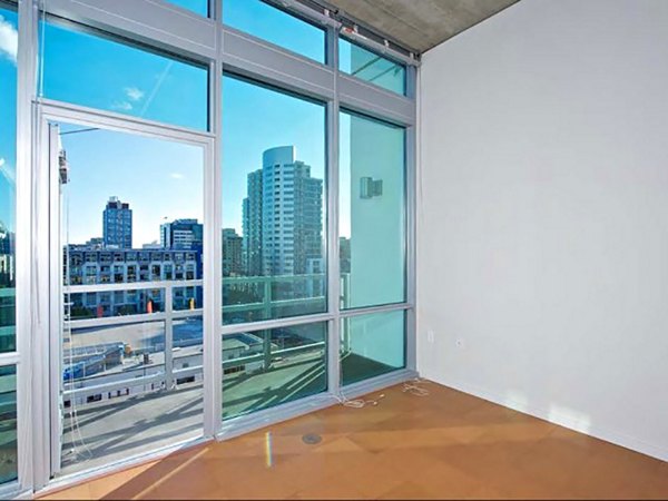 Bright living room with modern decor and large windows at Tenth&G Apartments