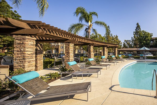 Resort-style pool with lounge chairs at Avila at Rancho Santa Margarita Apartments, offering luxurious outdoor relaxation