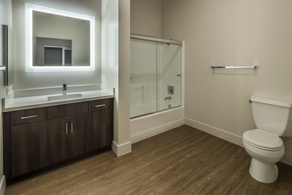 Bathroom featuring modern fixtures and white tiles at Holly Street Village Apartments