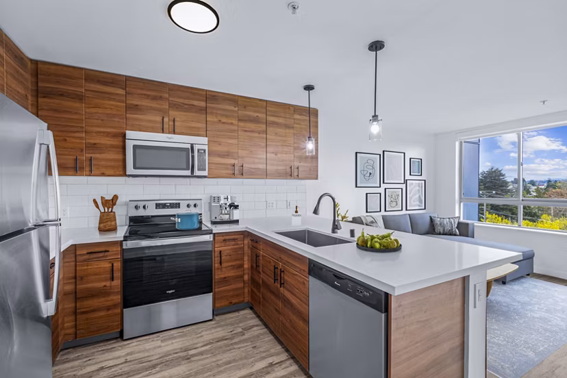 Kitchen featuring modern appliances and sleek countertops at The Station at Othello Park Apartments