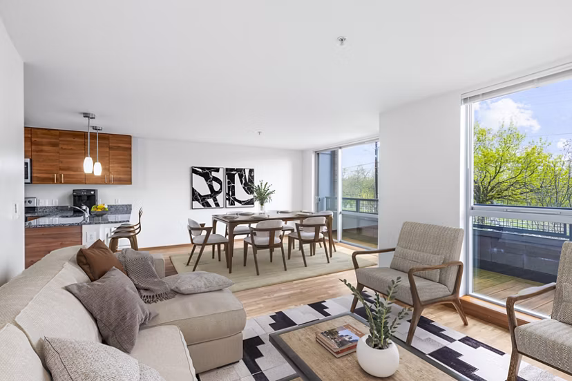 Modern living room with plush seating and natural light at The Station at Othello Park Apartments