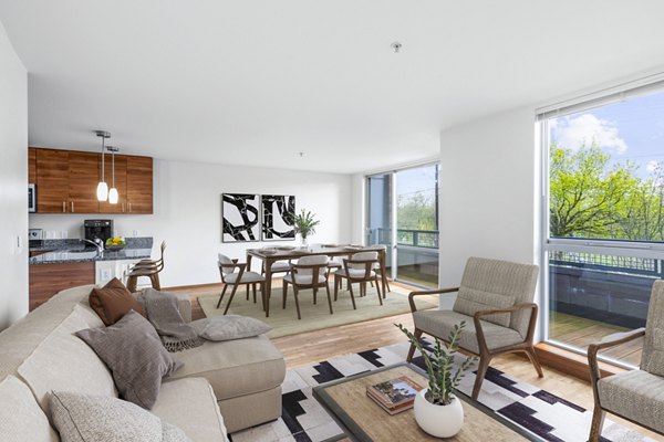 Modern living room with plush seating and natural light at The Station at Othello Park Apartments