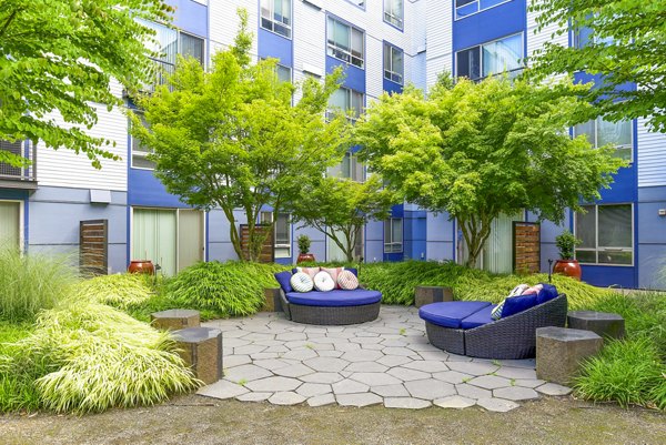 Courtyard patio with lush greenery at The Station at Othello Park Apartments, a luxury community offering outdoor relaxation spaces