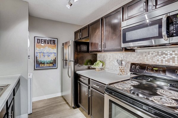 Modern kitchen featuring stainless steel appliances and granite countertops in Sage at Panorama Apartments