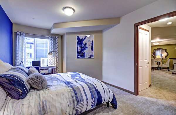 Cozy bedroom with modern decor at Harrington Square Apartments: luxury living by Greystar
