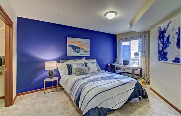 Cozy bedroom with modern decor at Harrington Square Apartments, a luxury property by Greystar