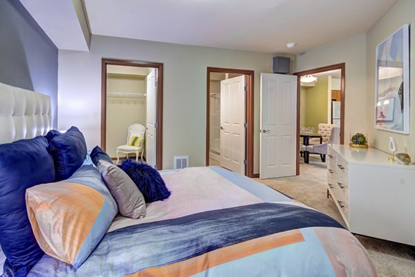 Cozy bedroom with modern furnishings at Harrington Square Apartments offering luxury living in a prime location