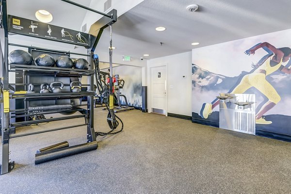 Modern fitness center equipped with cardio machines and weights at Village Creek at Brookhill Apartments