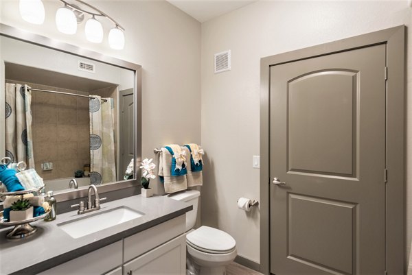 Modern bathroom featuring sleek fixtures and elegant tiling in Deseo at Grand Mission Apartments