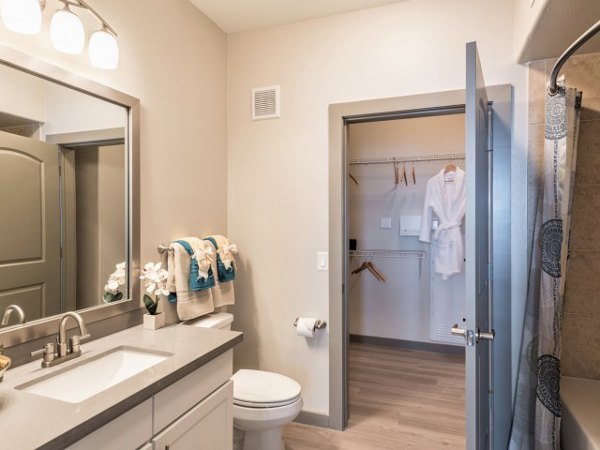 Bathroom with modern fixtures and marble-topped vanity at Deseo at Grand Mission Apartments