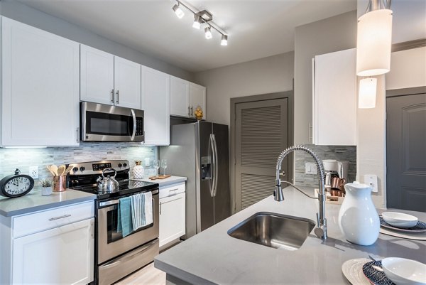 Deseo at Grand Mission Apartments: Modern kitchen with stainless steel appliances and granite countertops